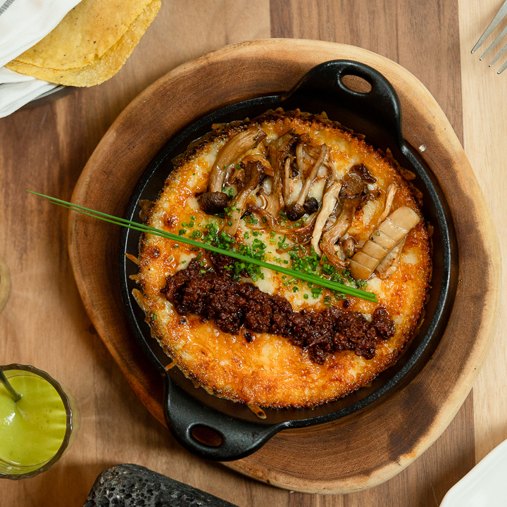 Traditional Mexican queso fundido melted cheese served hot at at Cuerno Mexican steakhouse in New York City Traditional Mexican queso fundido melted cheese served hot at at Cuerno Mexican steakhouse in New York City